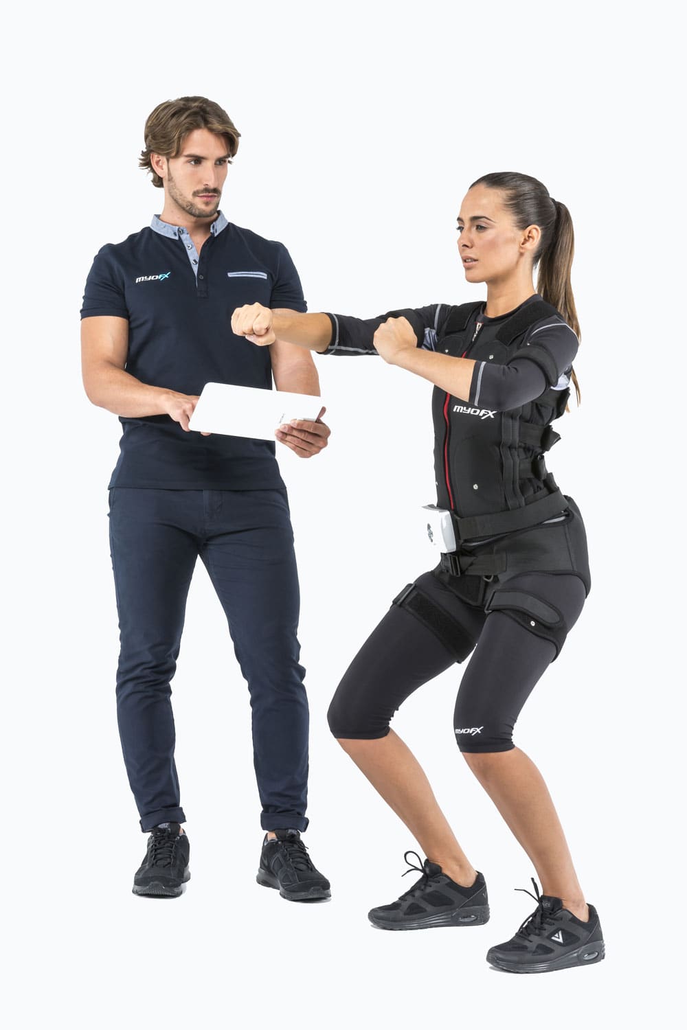 Begeleider met tablet naast een vrouw die traint in een EMS pak
